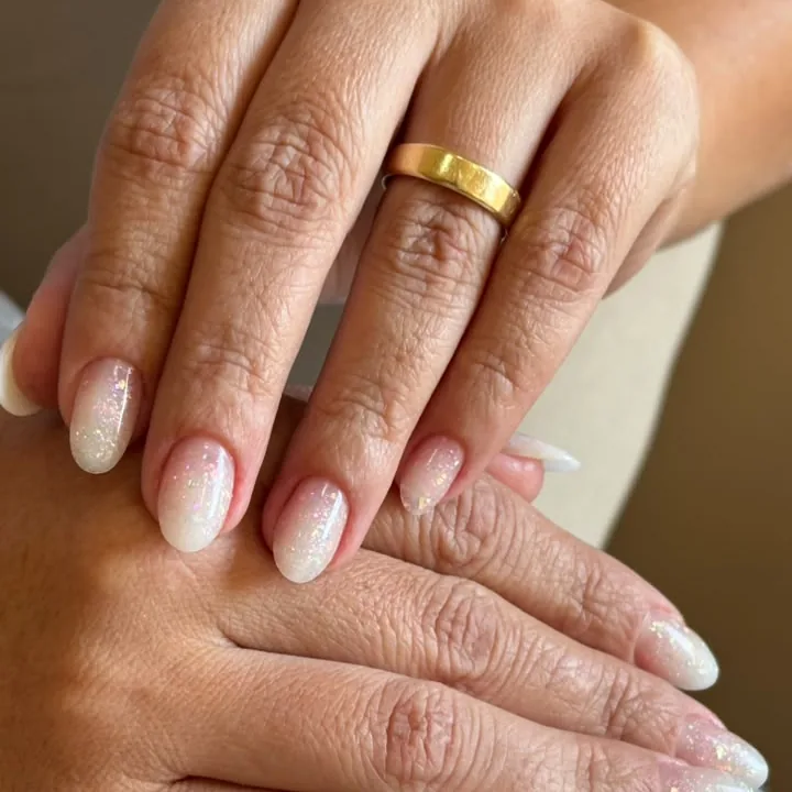 Unhas em gel com francesinha branca e anel dourado
